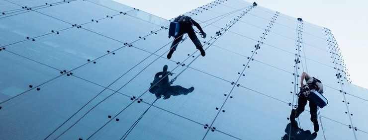low-angle-shot-of-two-persons-rappelling-at-the-side-of-a-tall-building_181624-24114.jpg